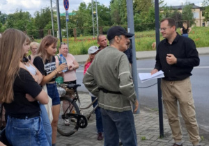 Kilka osób stojących na chodniku.
