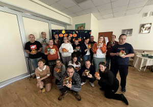 Grupa osób trzymająca w rękach wykonane lampiony.