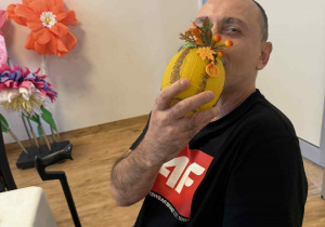 Mężczyzna w czarnej koszulce trzyma w ręku żółty lampion.