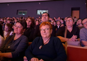 Grupa osób siedząca na widowni.