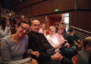 Grupa osób siedząca na widowni.