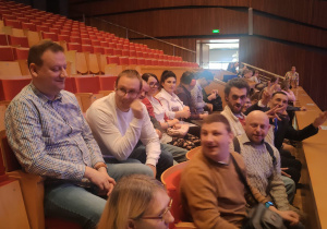 Grupa osób siedząca na widowni.