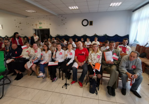 Grupa osób czeka z niecierpliwością na rozpoczęcie uroczystości.