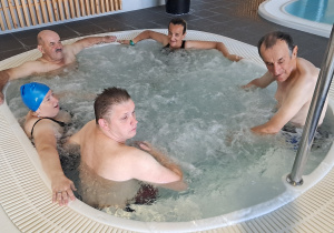 Grupa osób zażywa kąpieli w jacuzzi