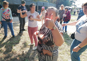 Kilka tańczących osób. Kobieta pokazuje kciuka na znak dobrej zabawy.