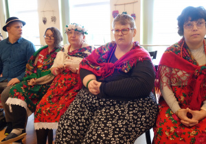 Grupa osób ubrana w góralskie stroje .